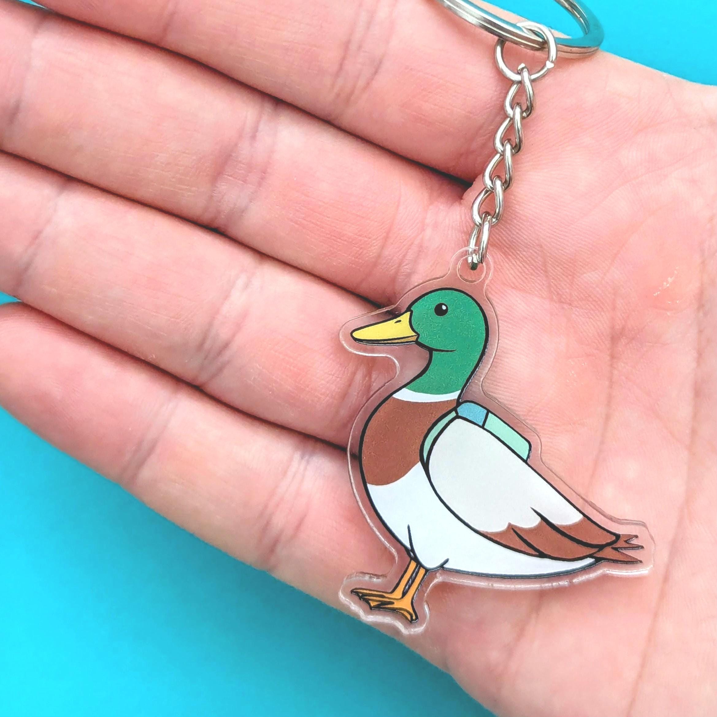 Mallard duck keychain held in a hand with a blue background