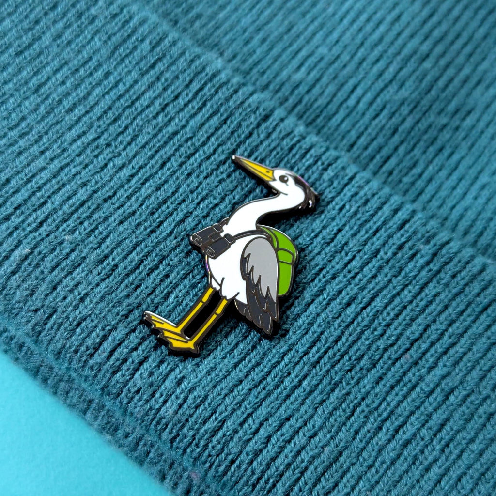 heron pin on a textured blue fabric background