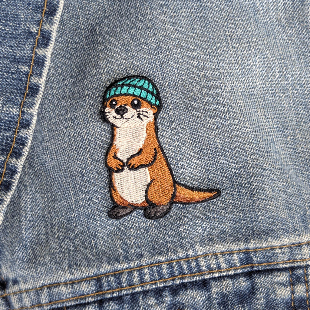 Embroidered otter patch on a denim background
