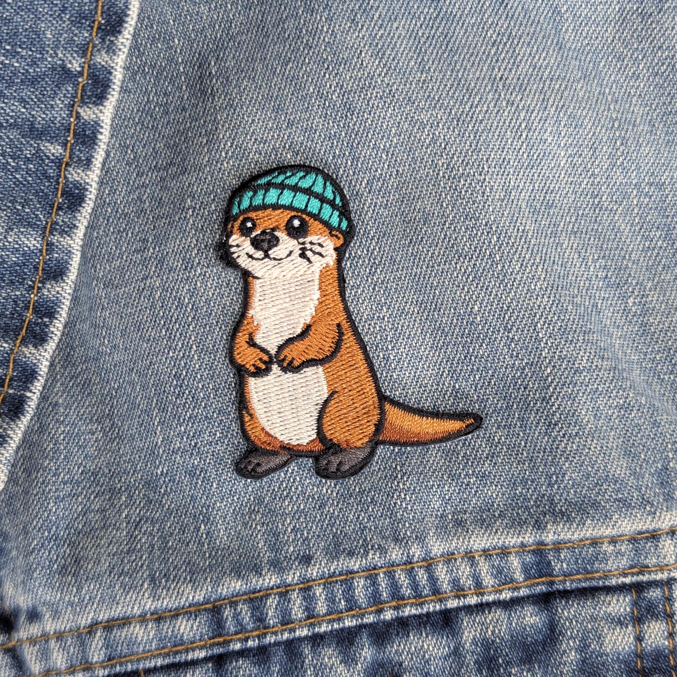 Embroidered otter patch on a denim background