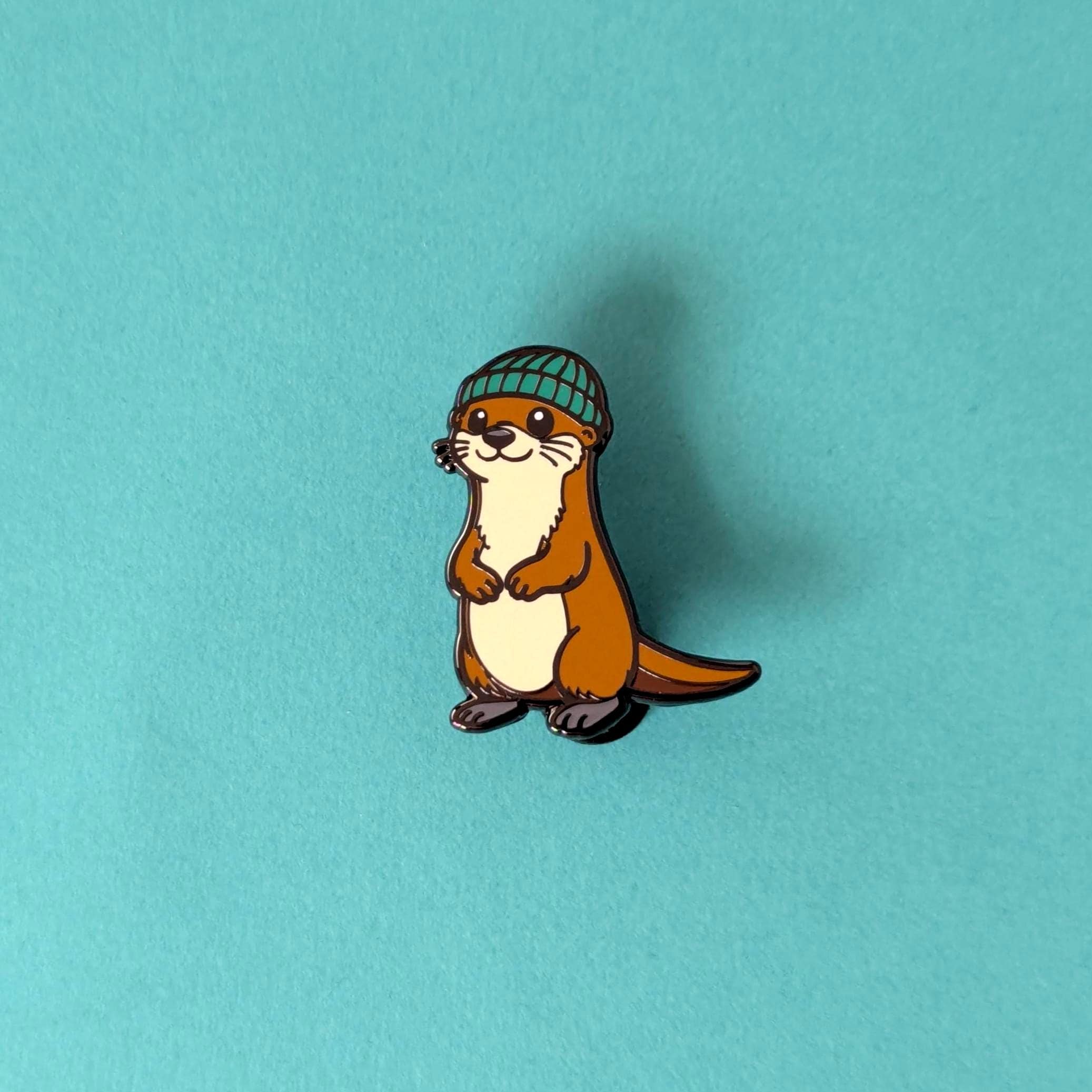 Animated otter wearing a green beanie on a teal background