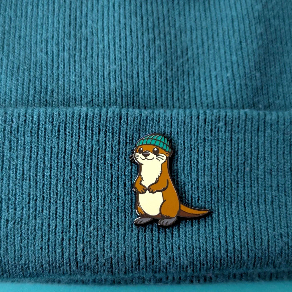 Otter wearing a green beanie on a blue textured background