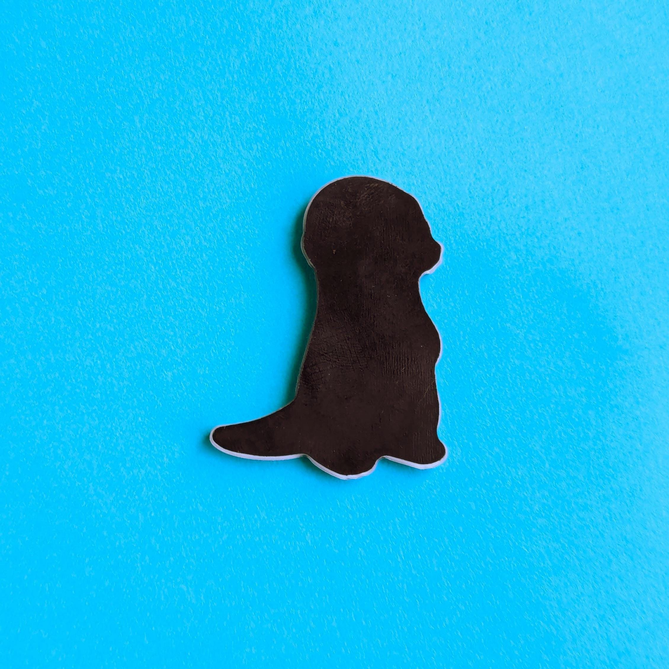 back view of otter fridge magnet on blue background
