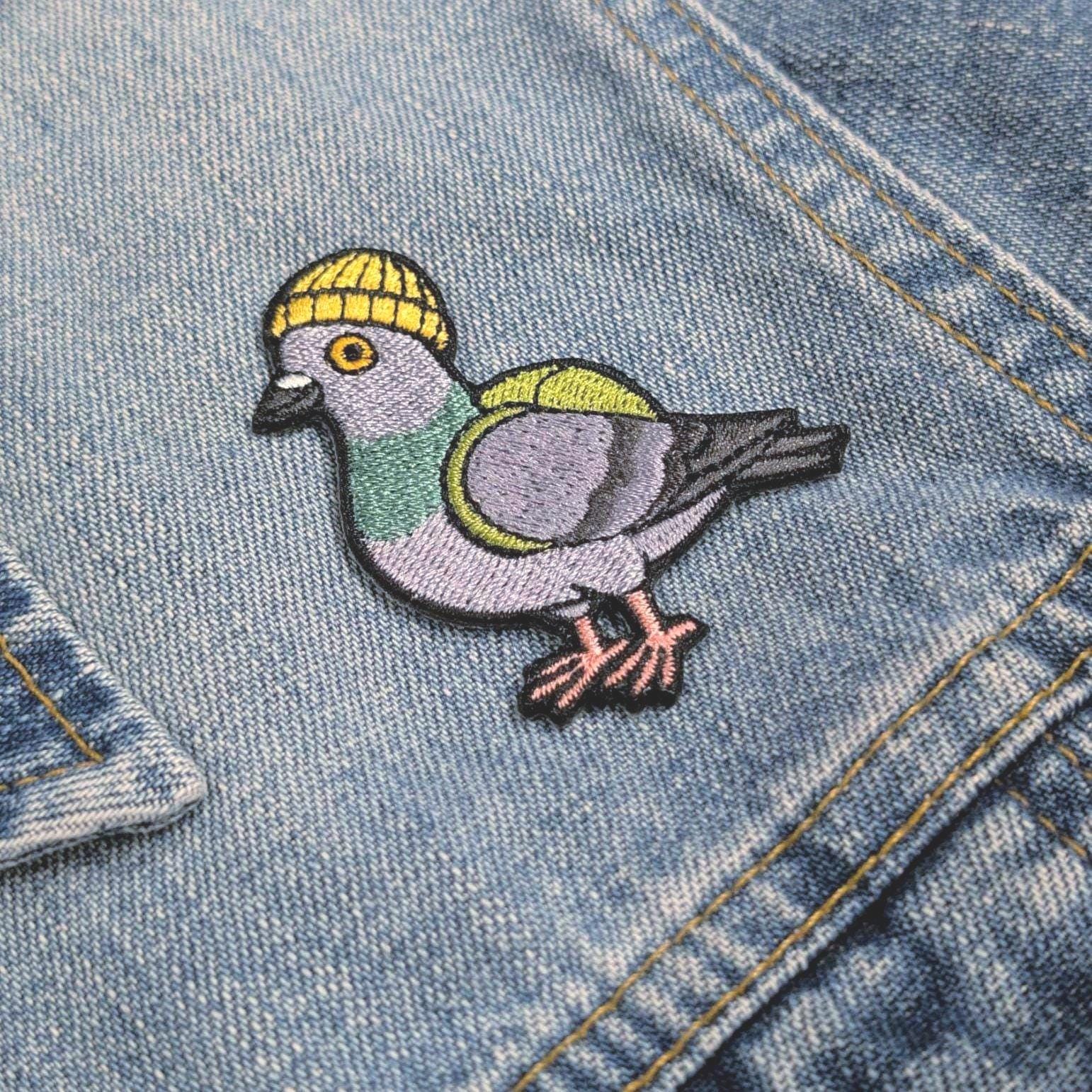 Embroidered pigeon patch on a denim jacket