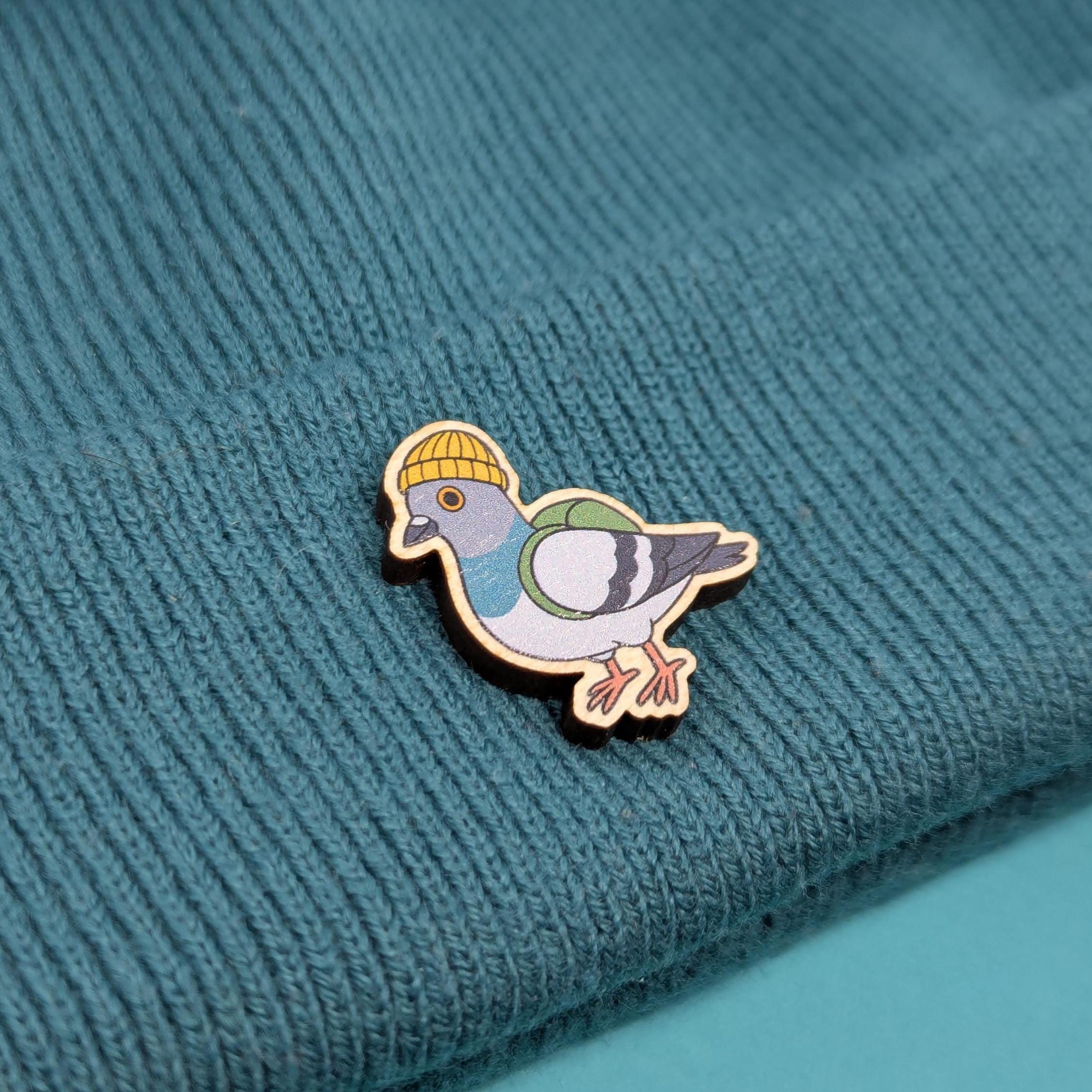 pigeon wooden pin on a textured teal fabric background