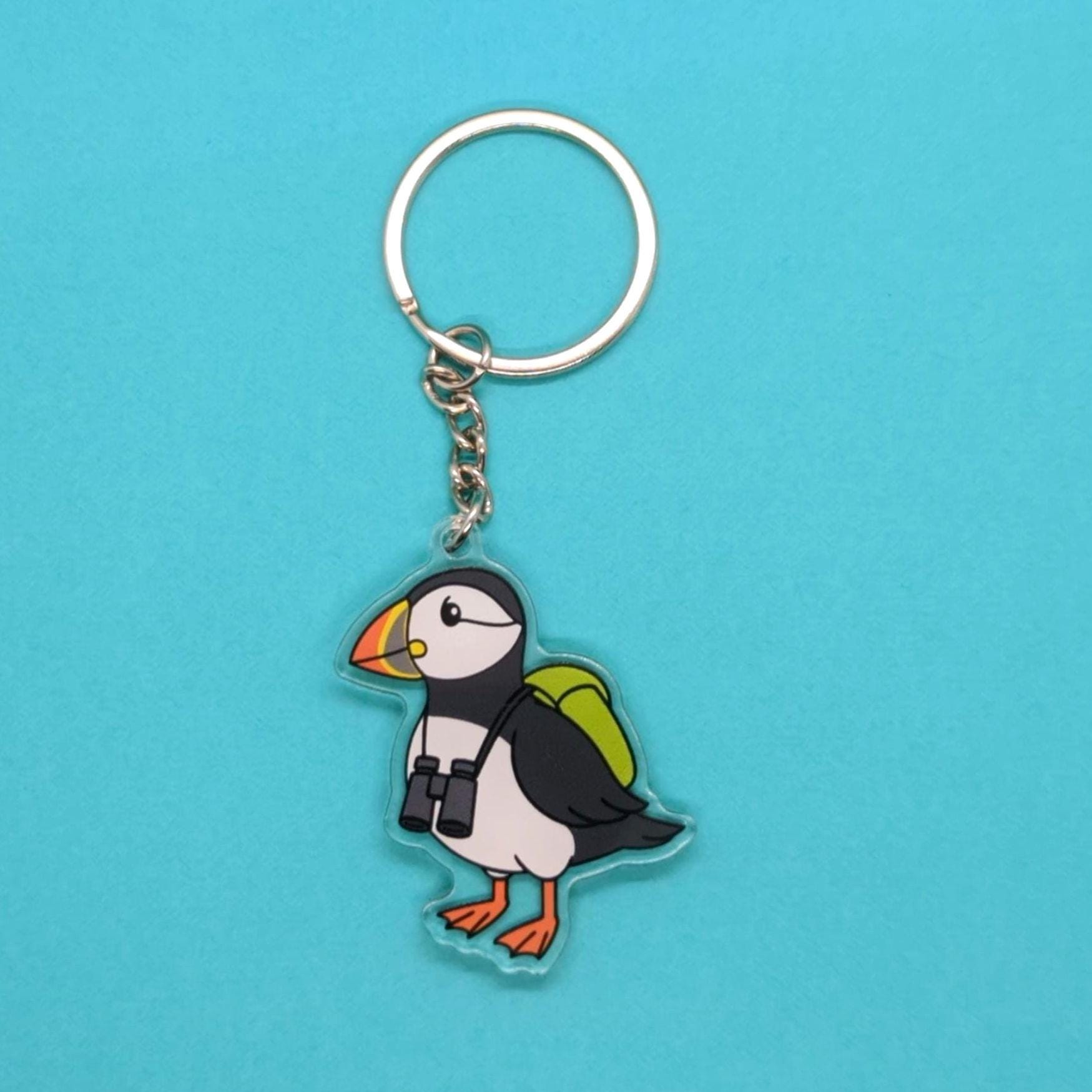Puffin keychain with a backpack on a blue background