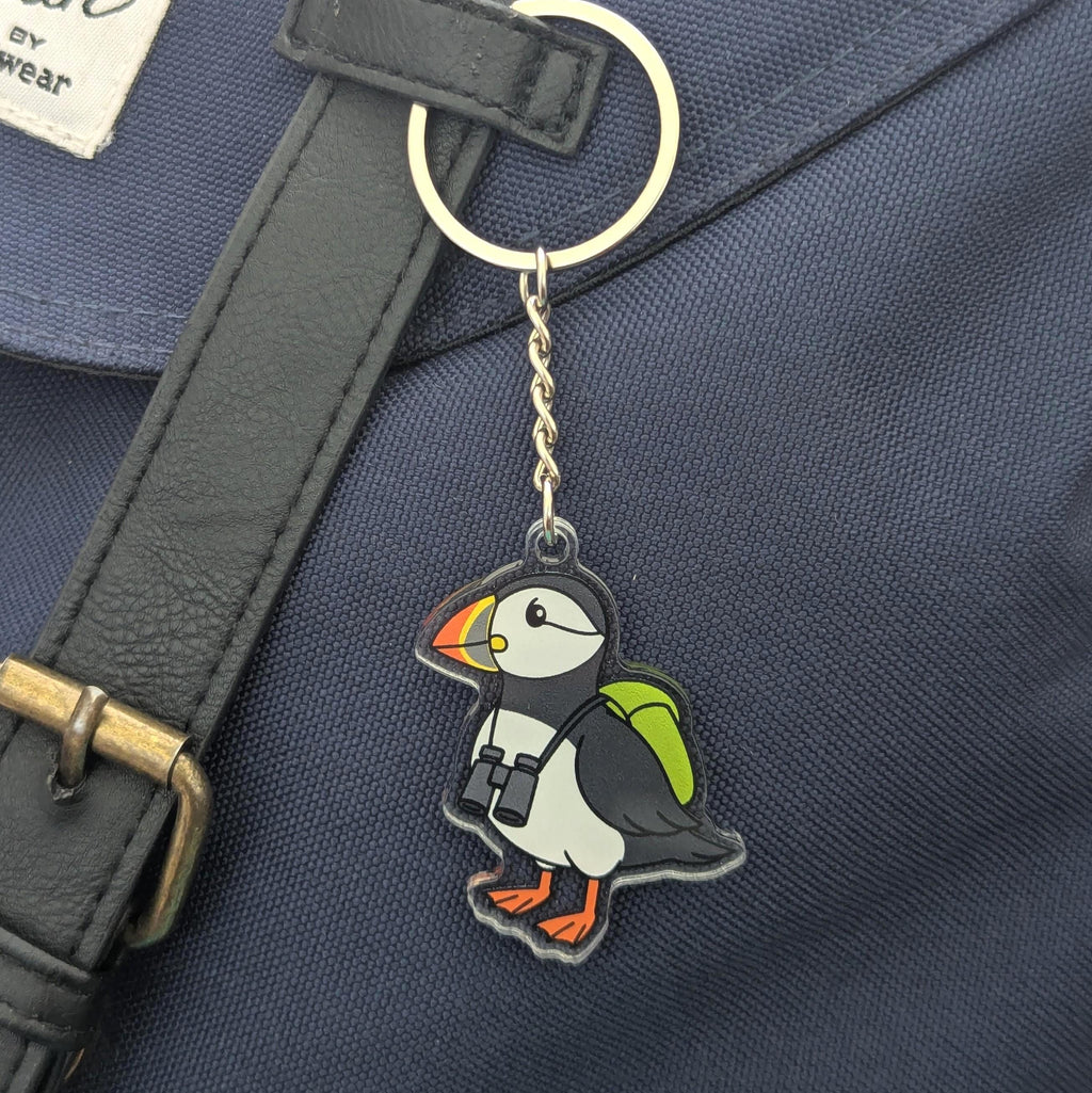 Puffin keychain attached to a dark blue bag with a strap.