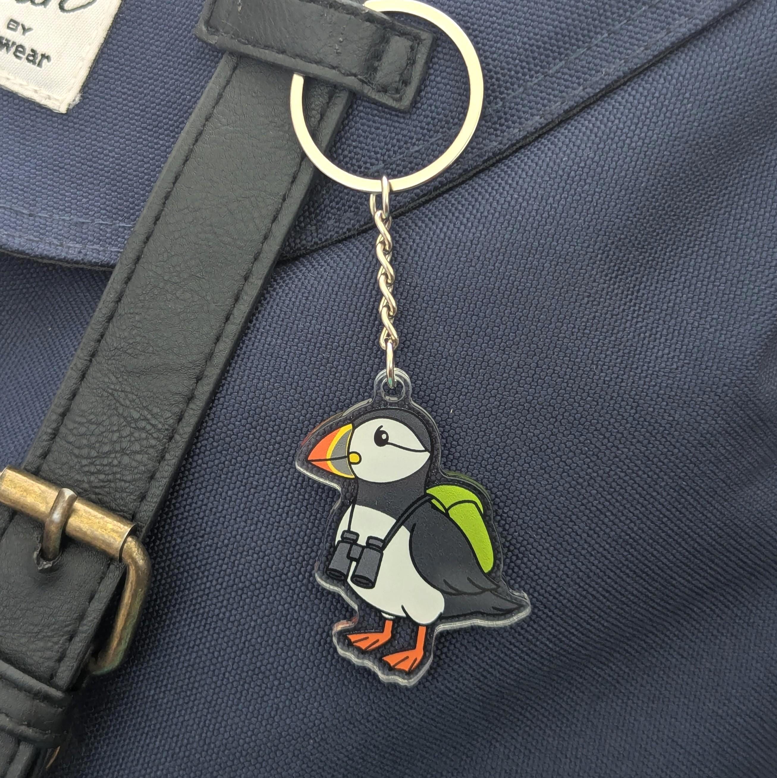 Puffin keychain attached to a dark blue bag with a strap.