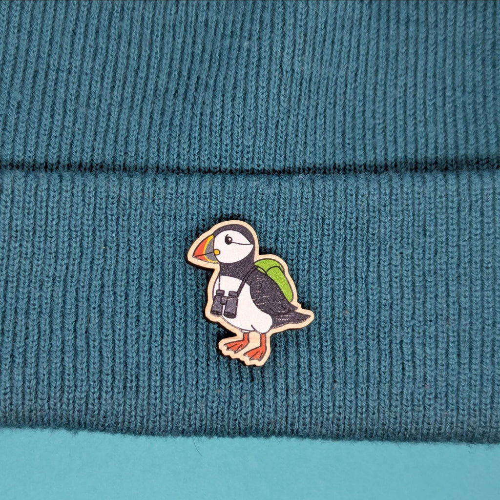 Puffin wooden pin on a teal knitted fabric background