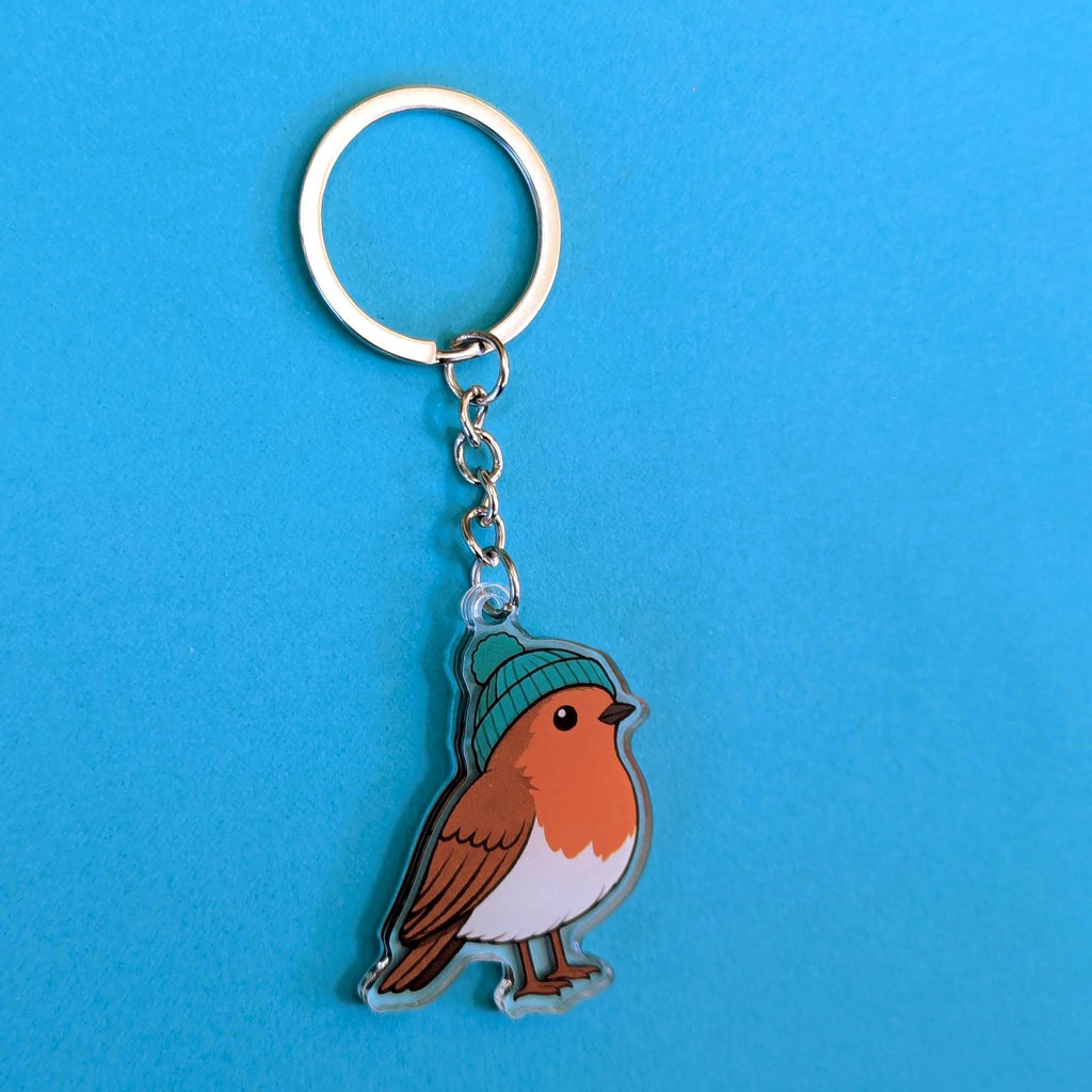 Keychain with a robin bird wearing a green hat on a blue background