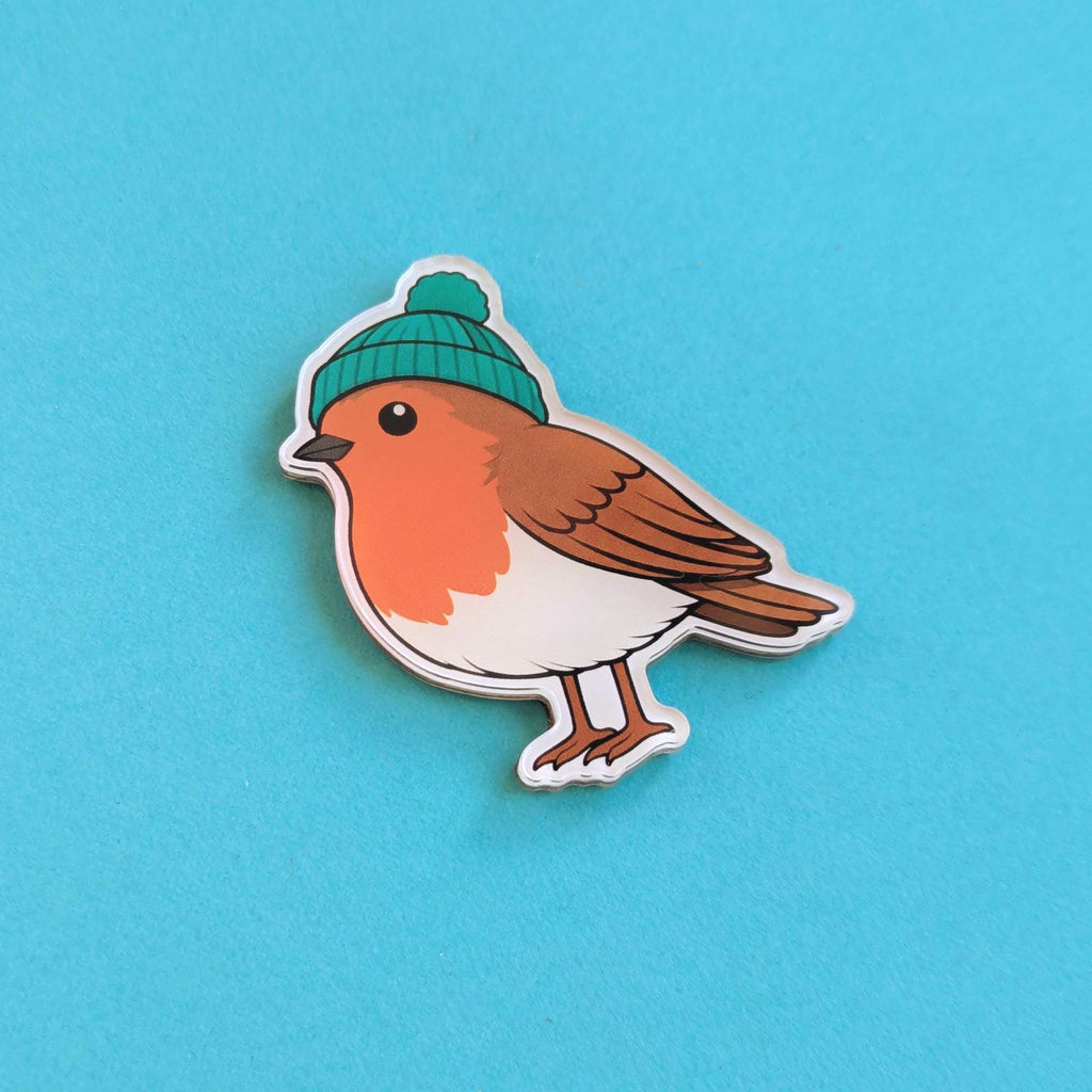 Bird fridge magnet with a green beanie on a blue background