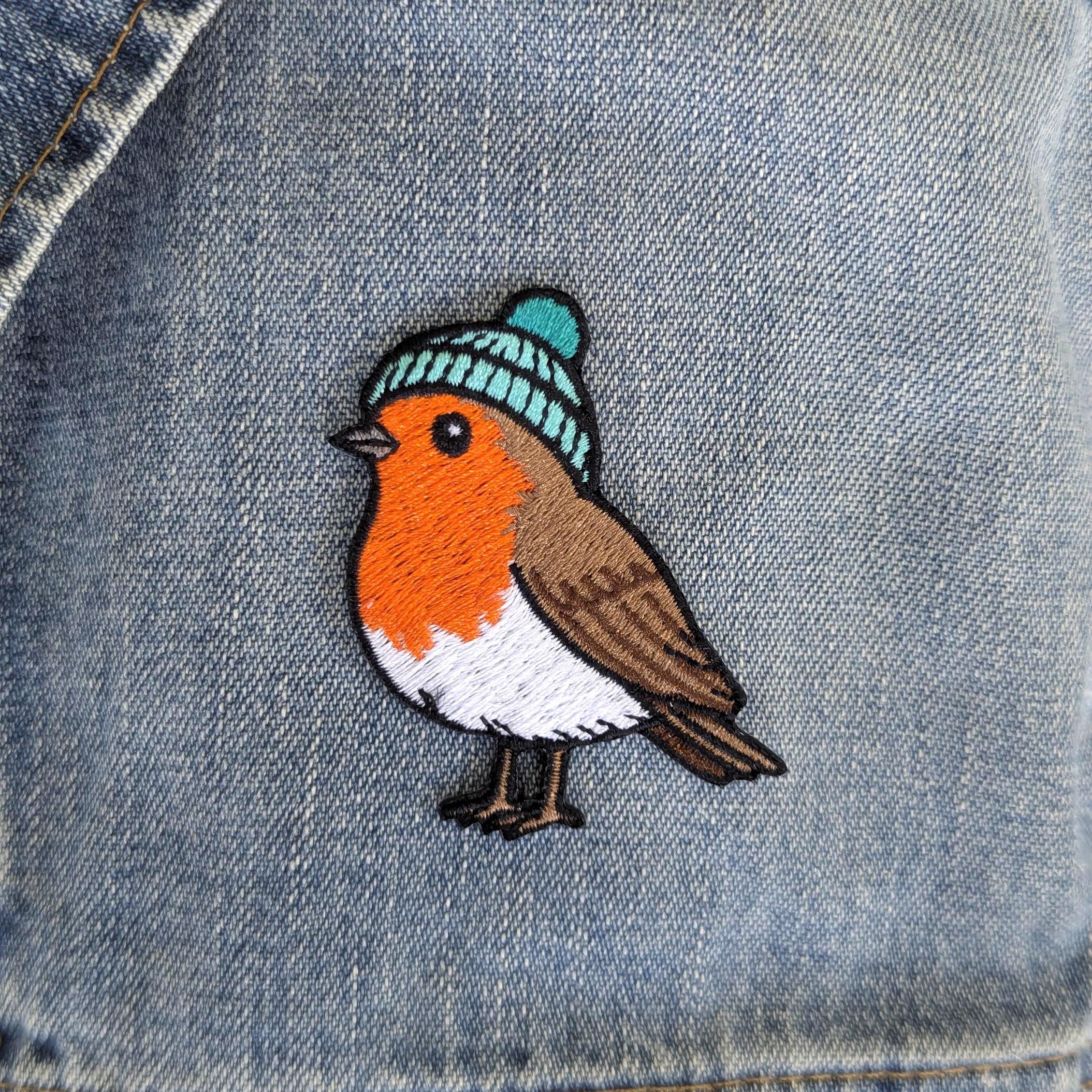 Robin bird patch with a blue beanie on denim fabric