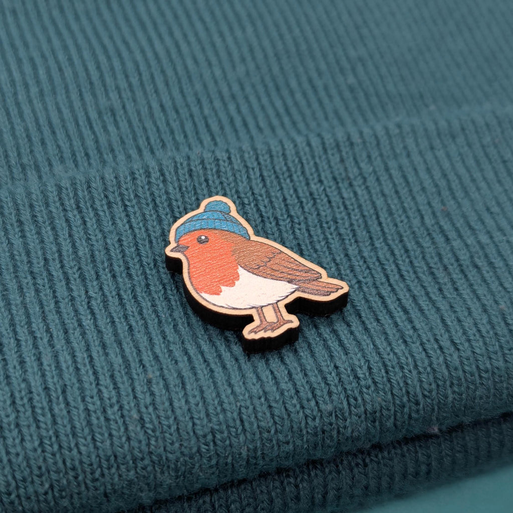 Robin wooden pin on a textured teal fabric background