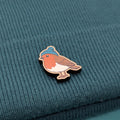 Robin wooden pin on a textured teal fabric background