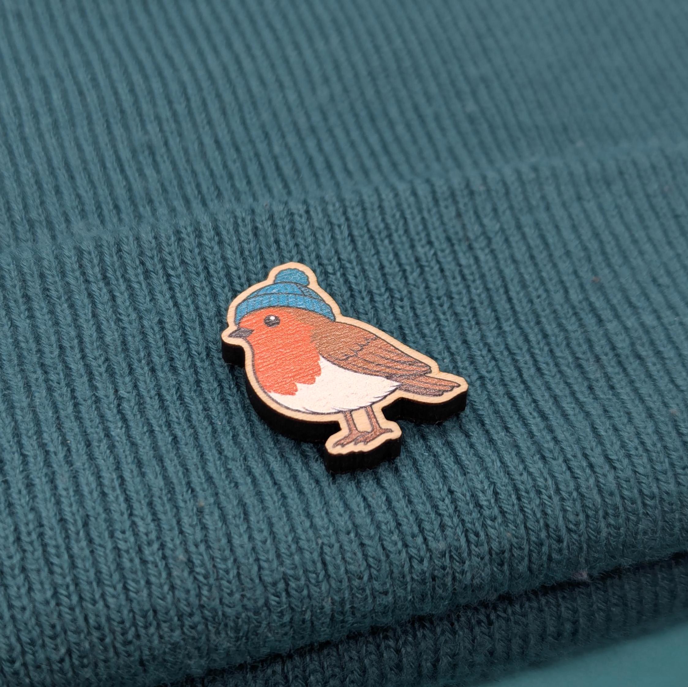 Robin wooden pin on a textured teal fabric background