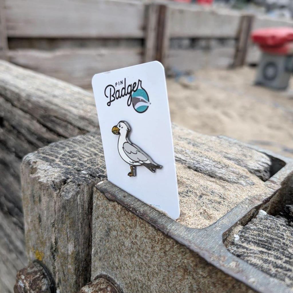 Seagull pin on a card with 'Pin Badger' branding, placed on wooden planks.
