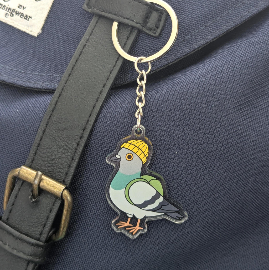 Urban pigeon keychain with a pigeon design on a blue bag