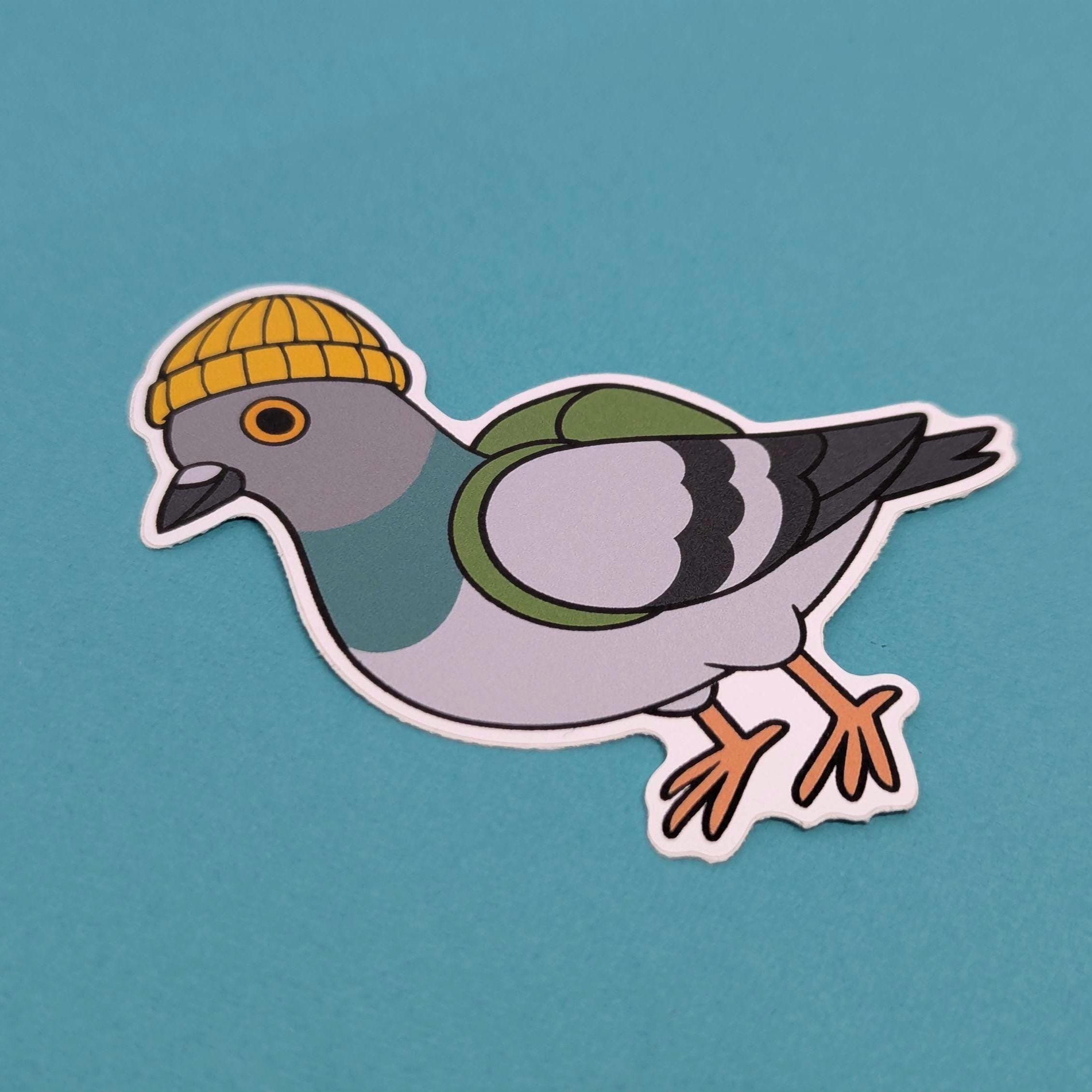 Sticker of a pigeon wearing a yellow beanie on a teal background