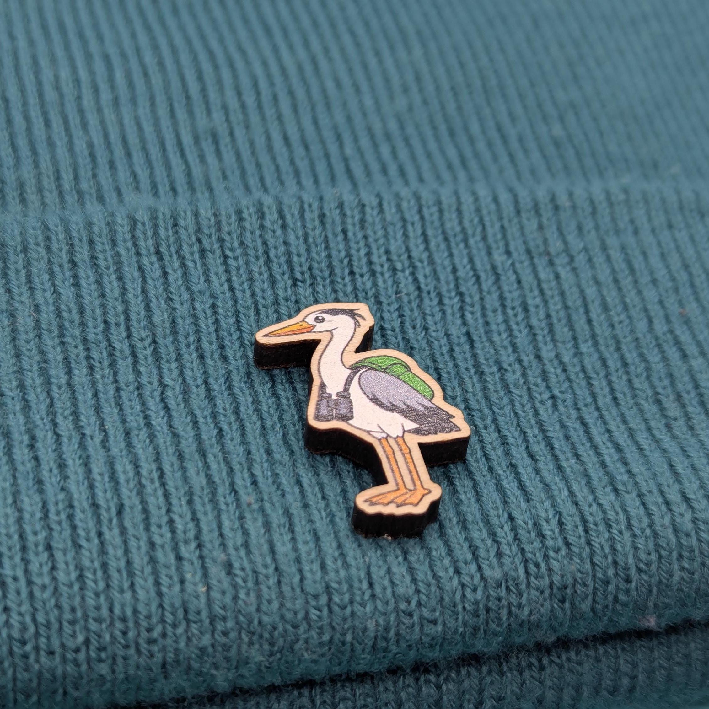 heron wooden pin on a textured teal fabric background