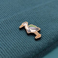 Wooden heron pin on a textured teal fabric background