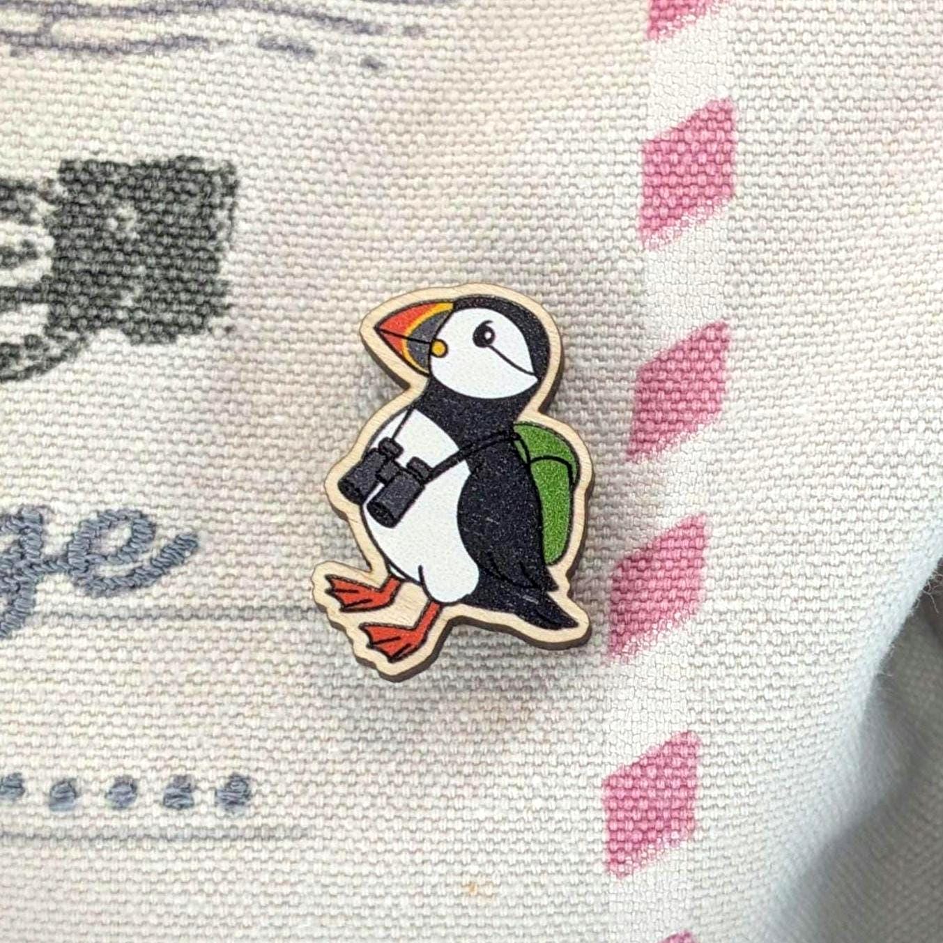 Wooden puffin pin on a fabric background