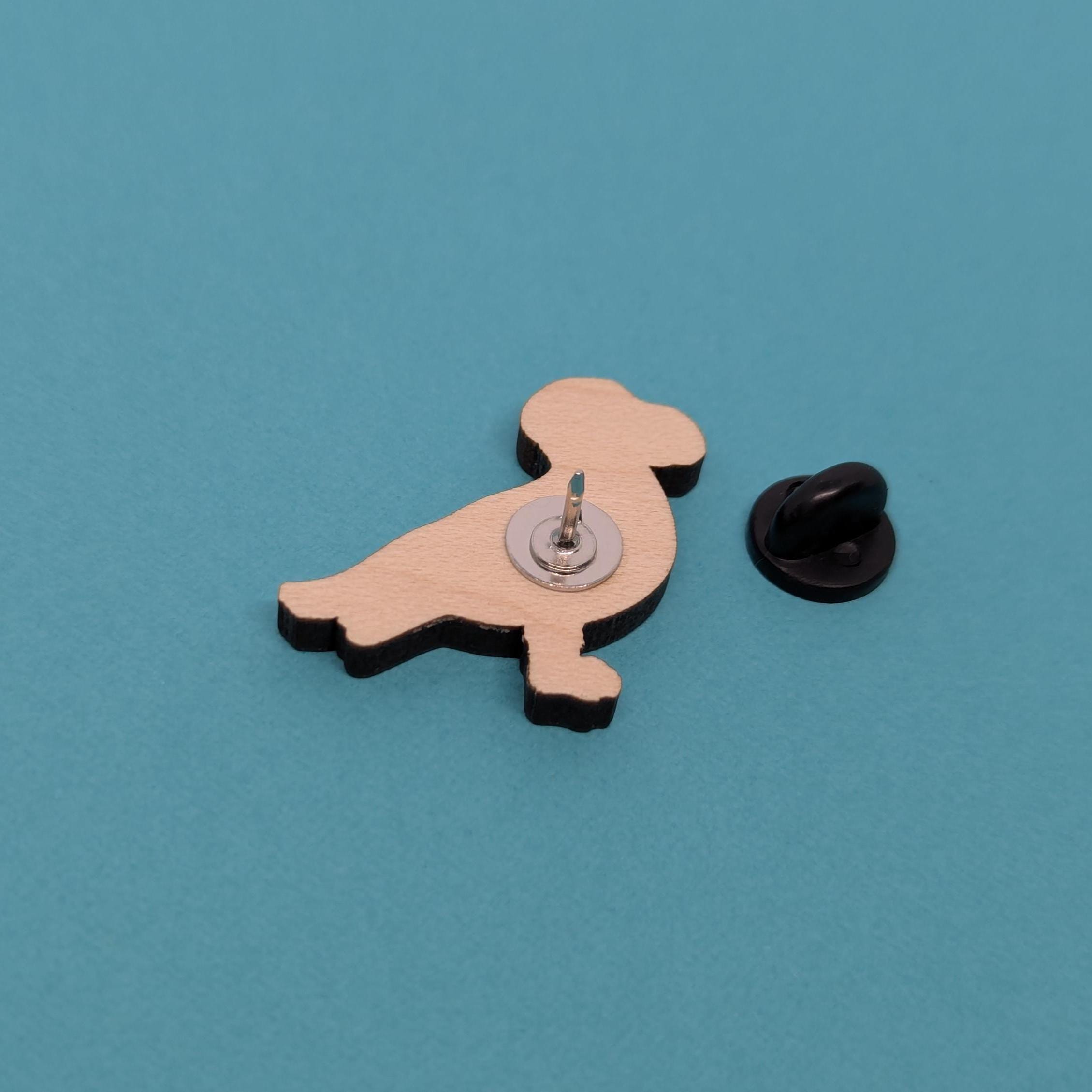 seagull wooden pin back with a black clutch back on a blue background