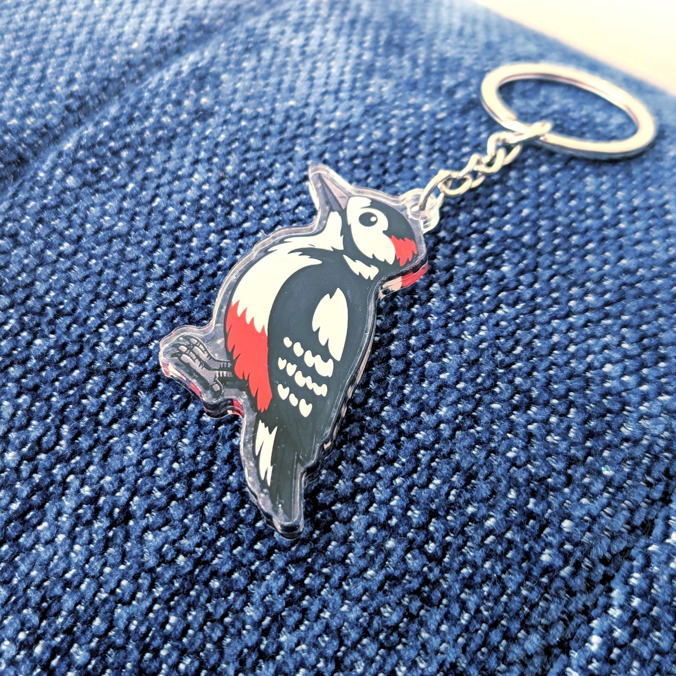 woodpecker keychain on a denim surface
