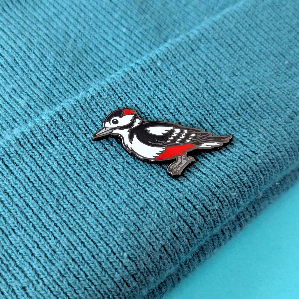 woodpecker pin on a textured blue fabric background