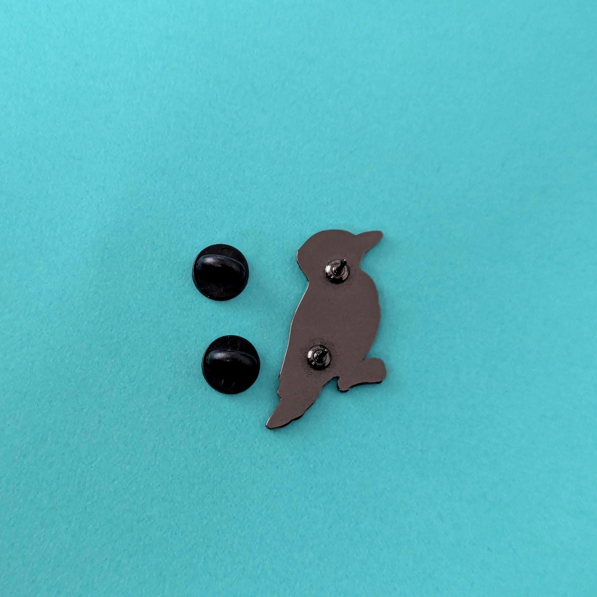 Bird-shaped button and two black buttons on a turquoise background