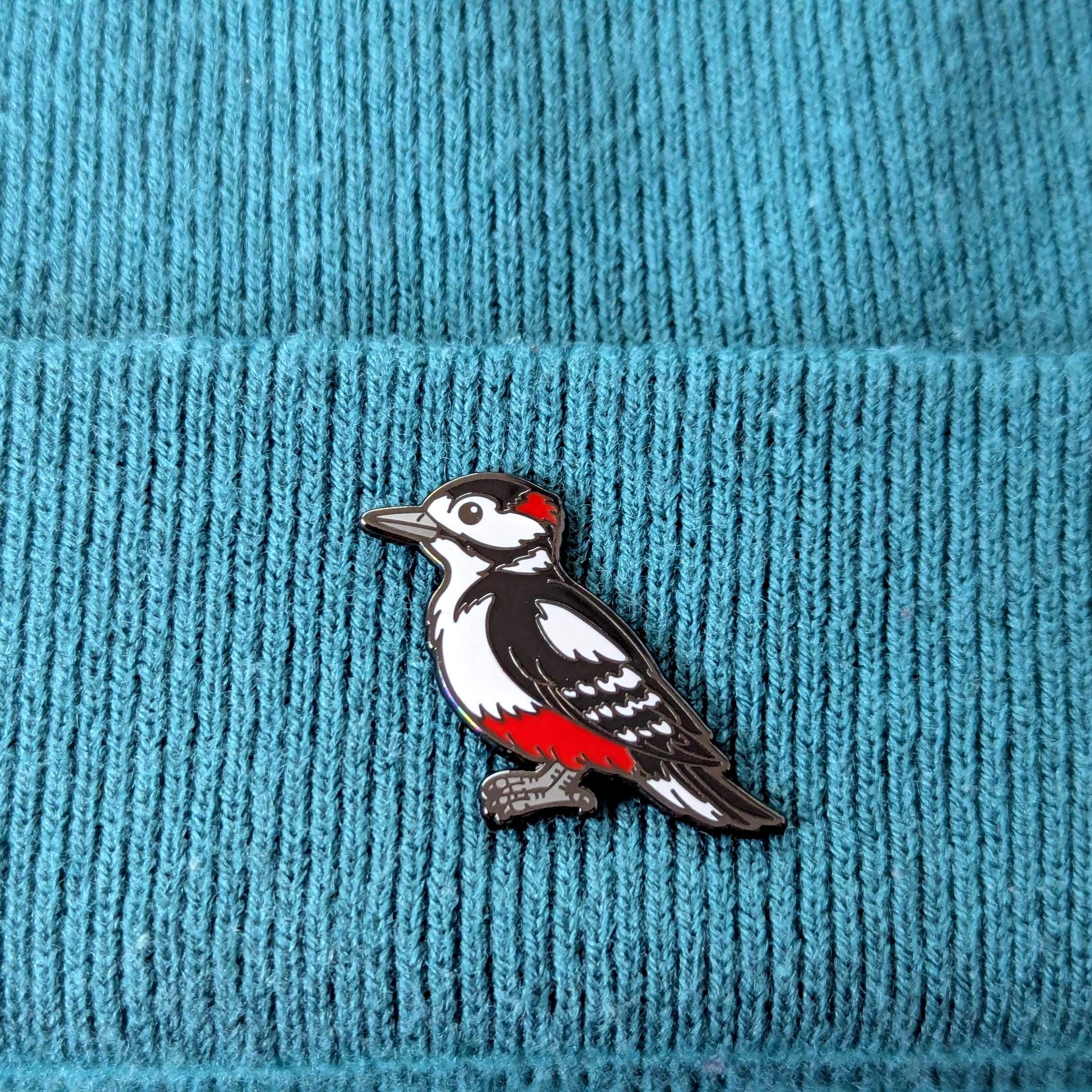 woodpecker pin on a blue textured fabric background