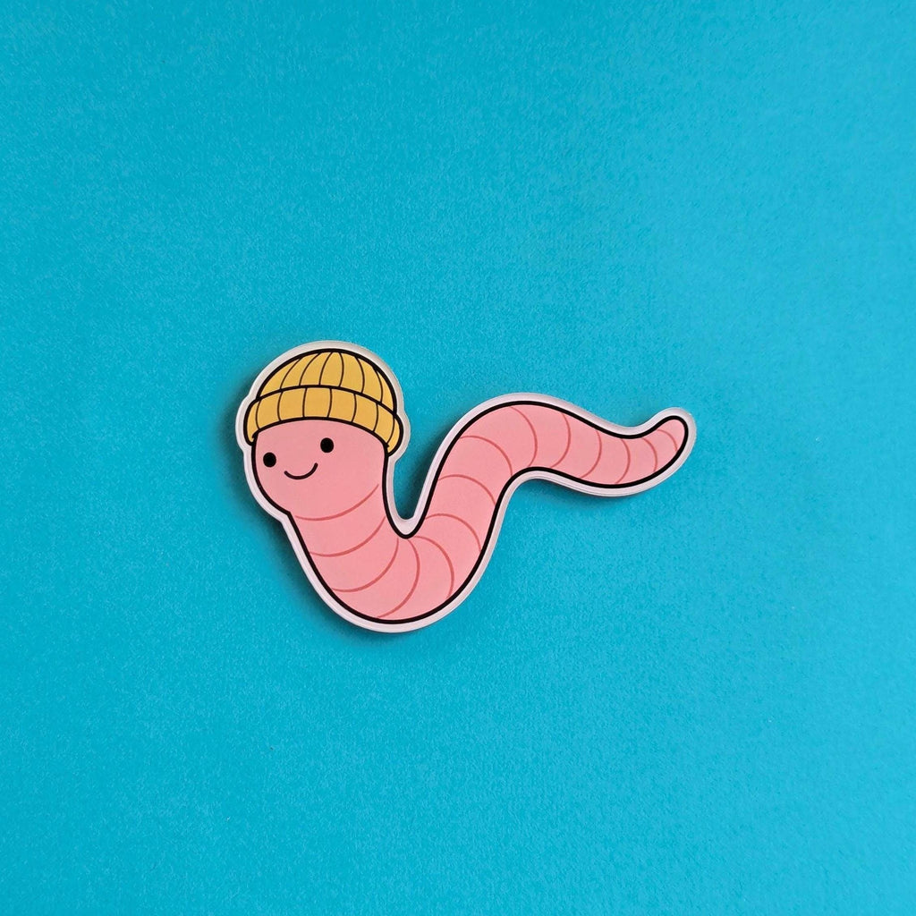 Fridge Magnet of a cartoon worm wearing a yellow hat on a blue background