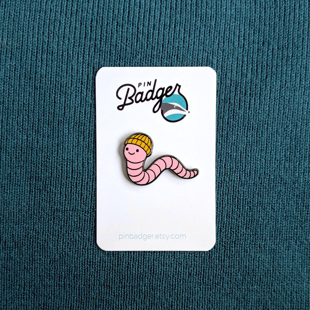Pin Badger worm pin on a white card against a teal background