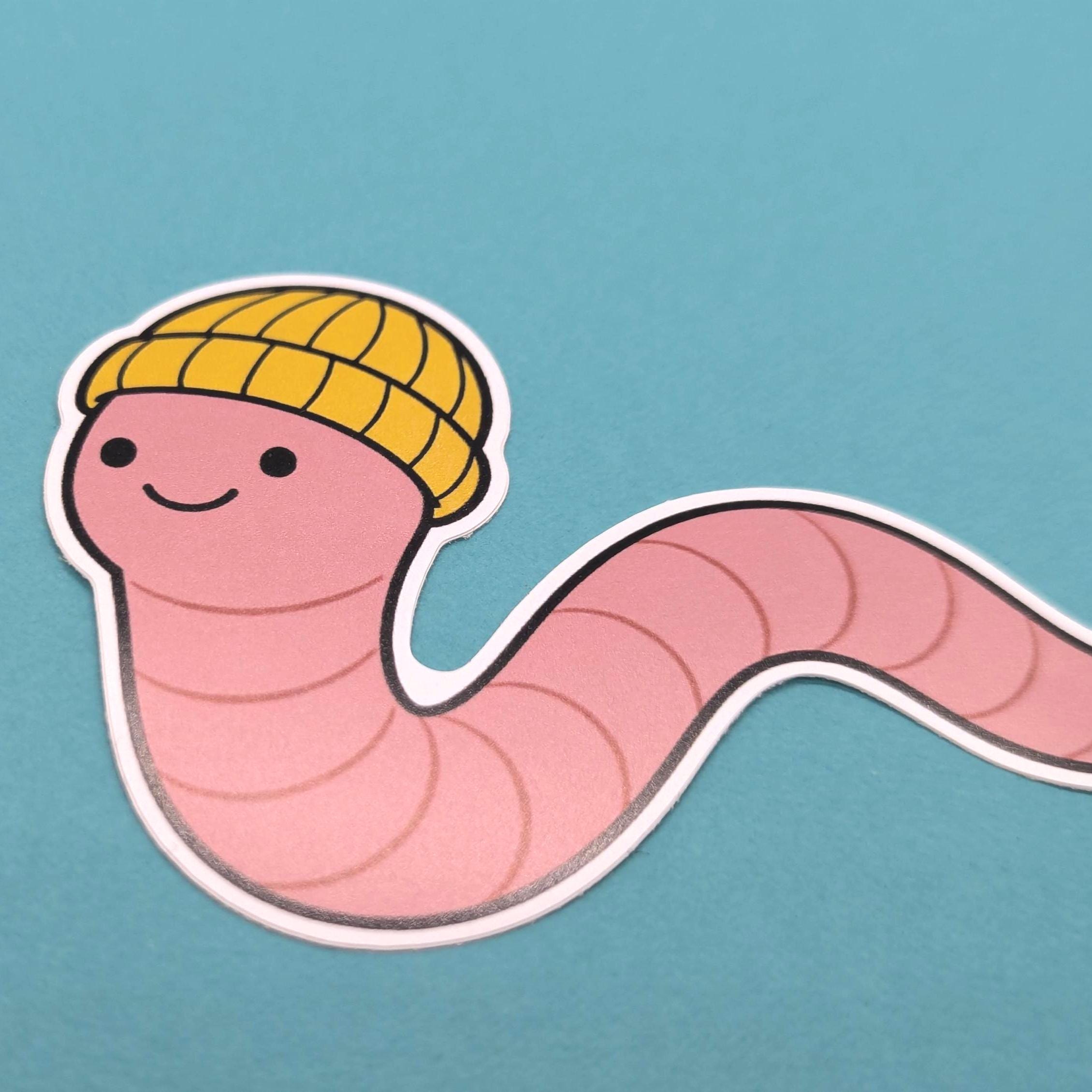 Cartoon worm wearing a yellow beanie on a blue background